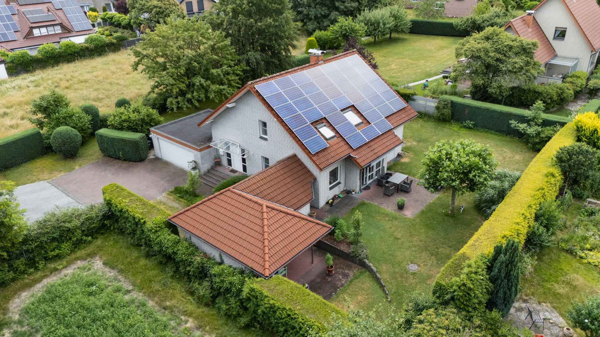 Luftaufnahme eines Einfamilienhauses mit Grundstück